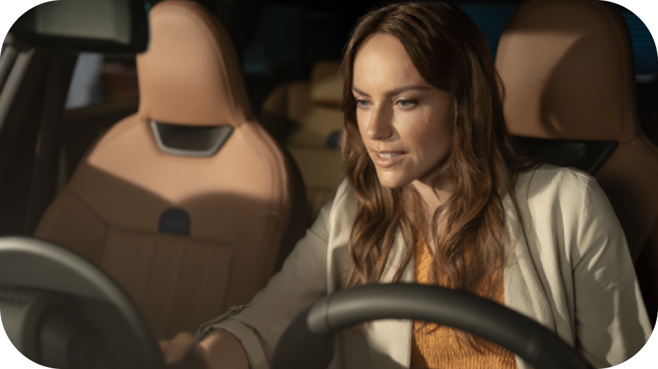 A woman looks down at the MINI OLED Display from the driver’s seat of her MINI. 