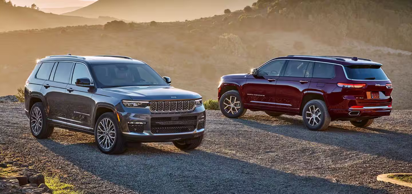 A gray and red jeep parked next to eachother.