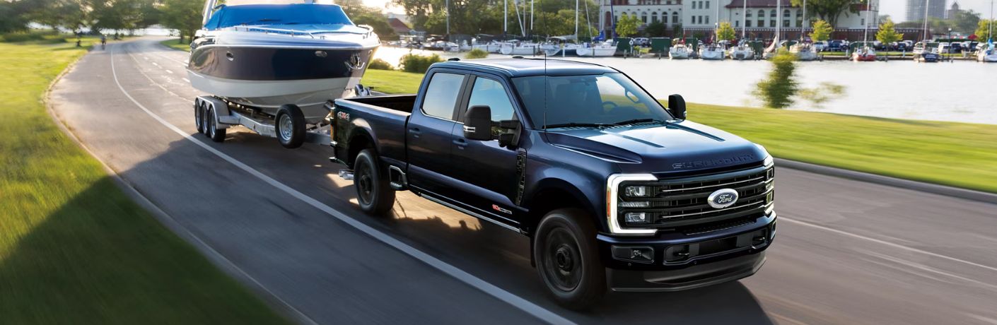 Black 2026 Ford Super Duty Towing Boat by a Marina