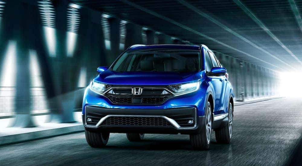 A blue 2020 Honda CR-V is shown driving on a city street.