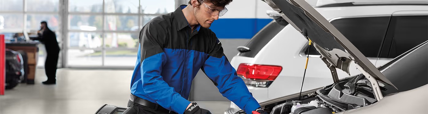 Service technician working on a vehicle in the service bay