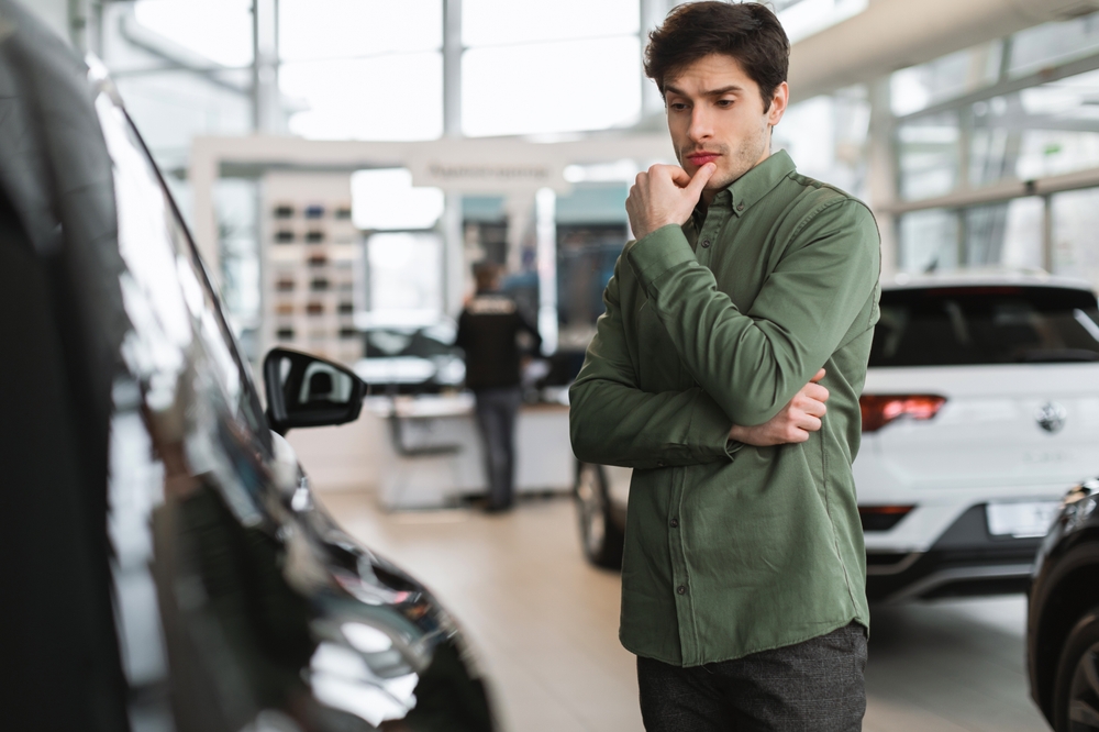 man thinking about buying a car at Kunes Auto Group dealership