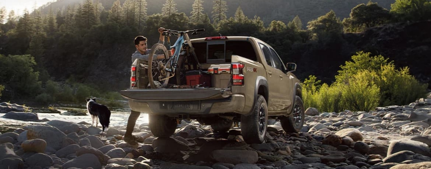 Nissan Frontier PRO-4X color beige estacionada cerca de un río