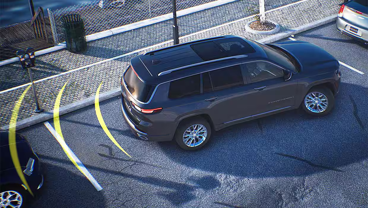 A silver car parking in a parking spot.