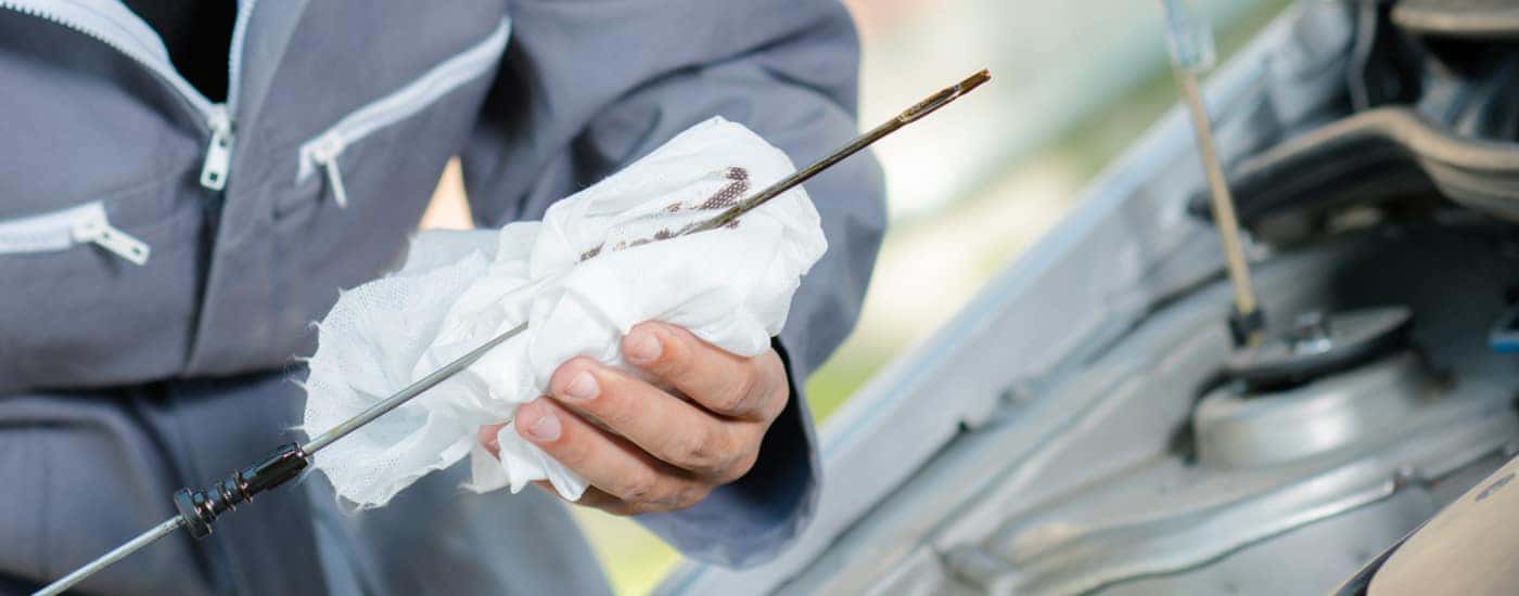 mechanic holding oil dipstick