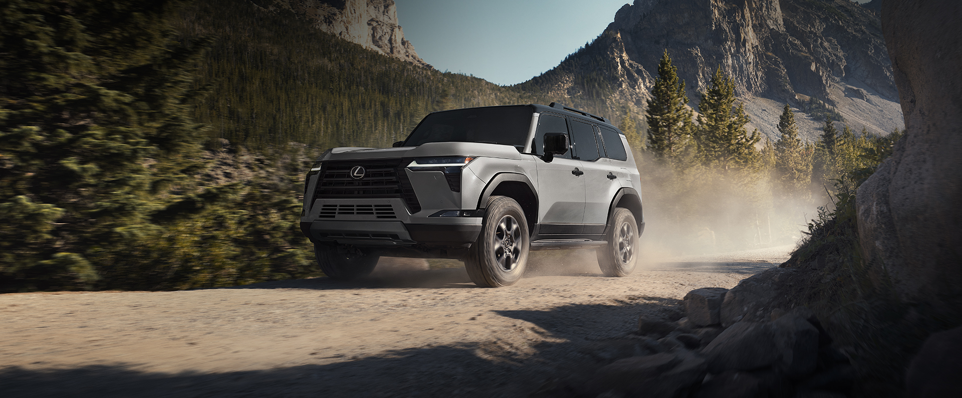 Exterior of a Lexus GX 550 Overtrail+ in Incognito with bi-tone Black Onyx roof driving on a mountain terrain.
