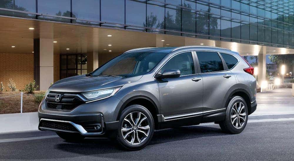 A silver 2020 Honda CR-V Touring is parked outside of a Honda dealer.