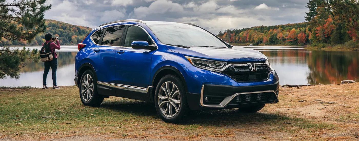 Blue 2022 Honda CR-V Touring parked in front of a lake