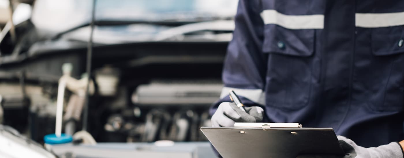 A mechanic is shown holding a clipboard at a transmission shop near Henrietta.