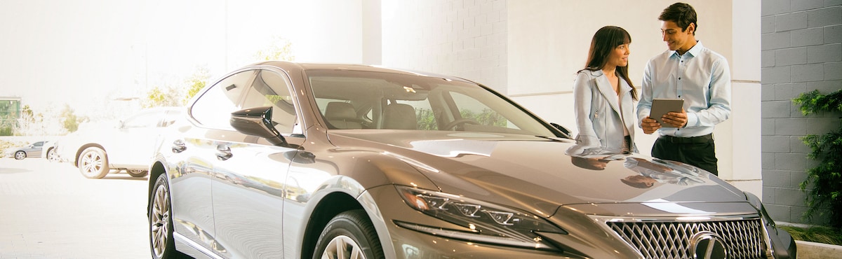 A man talking to a woman about her Lexus
