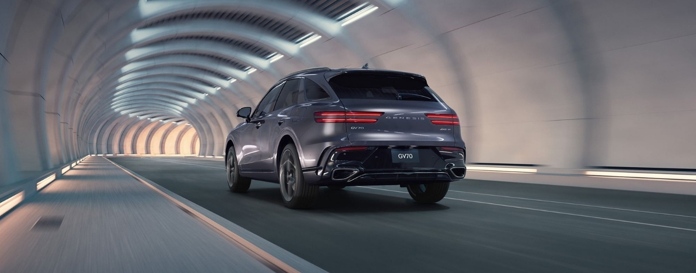 Rear of a grey 2026 Genesis GV70 driving through a tunnel