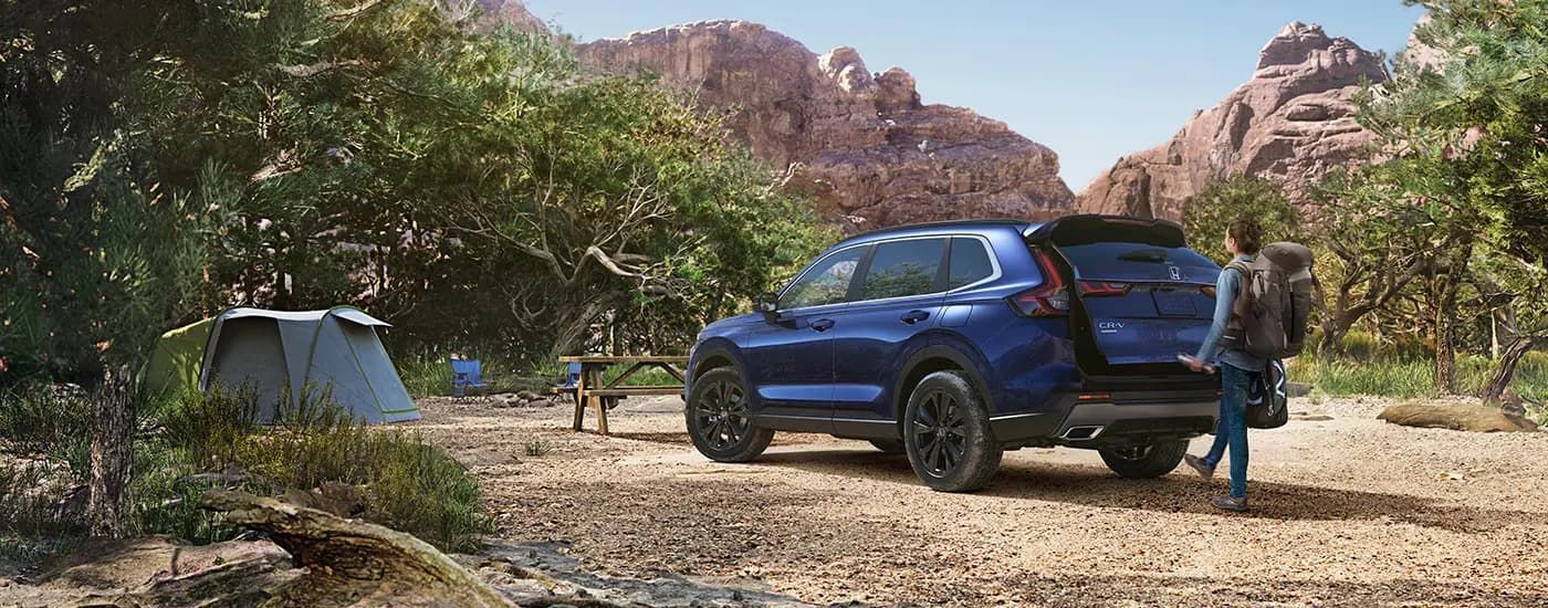 Blue 2025 Honda CR-V Sport Touring Hybrid parked on a campsite