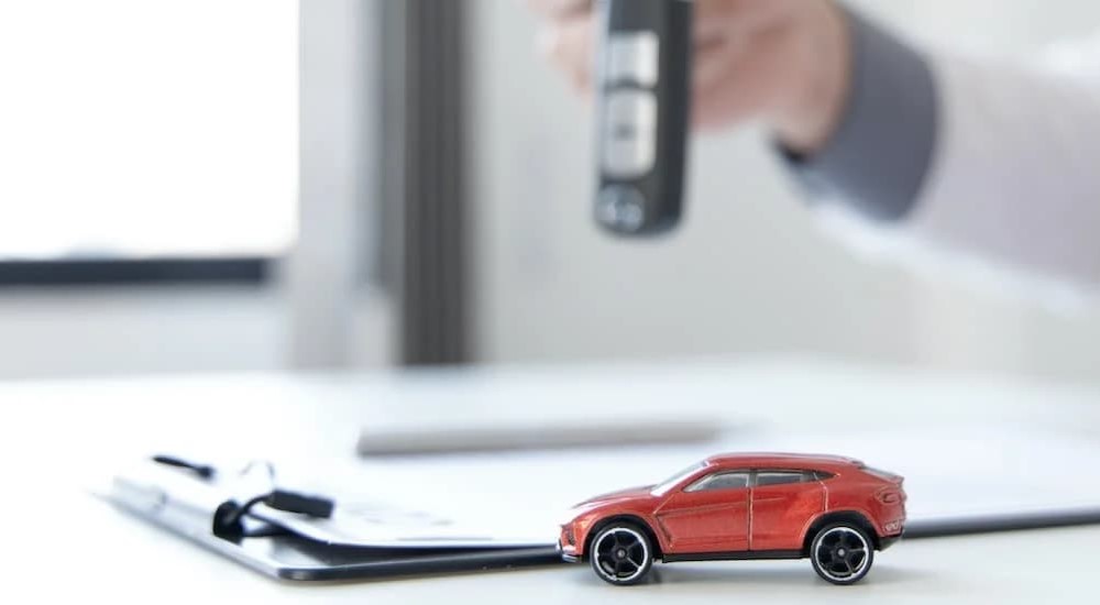 Toy car and clipboard on a desk