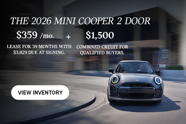 Front view of man driving grey MINI 2Door down a curved city street.