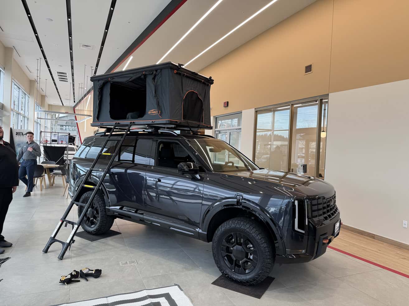 Kia Telluride with rooftop tent in a showroom
