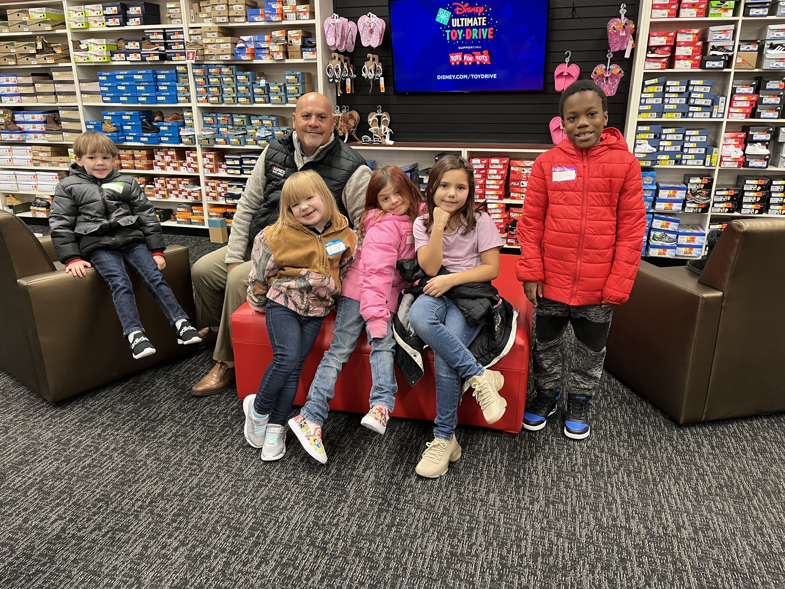 Representative from Kunes poses with 5 Eagle Ridge students in Shoe Dept Encore