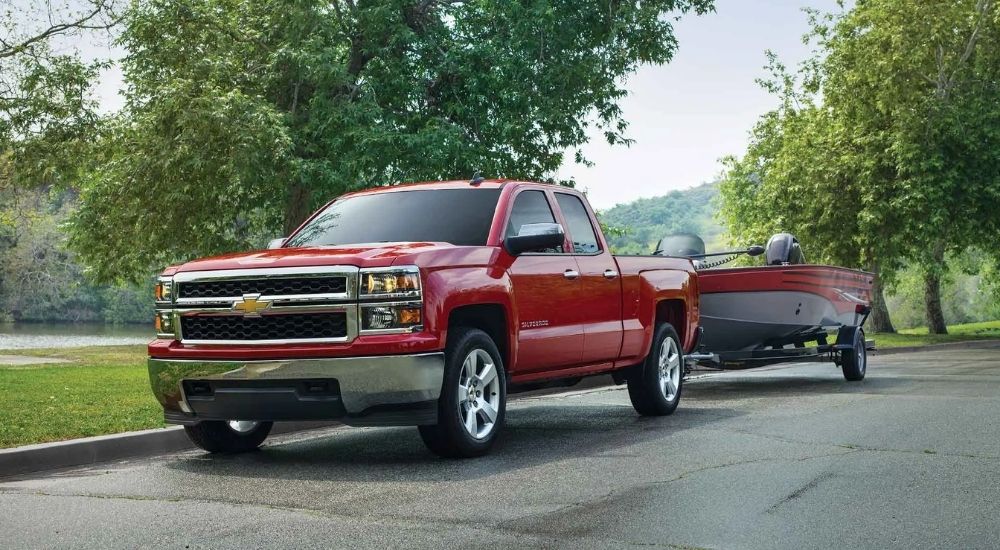Red 2015 Chevy Silverado 1500 towing a boat