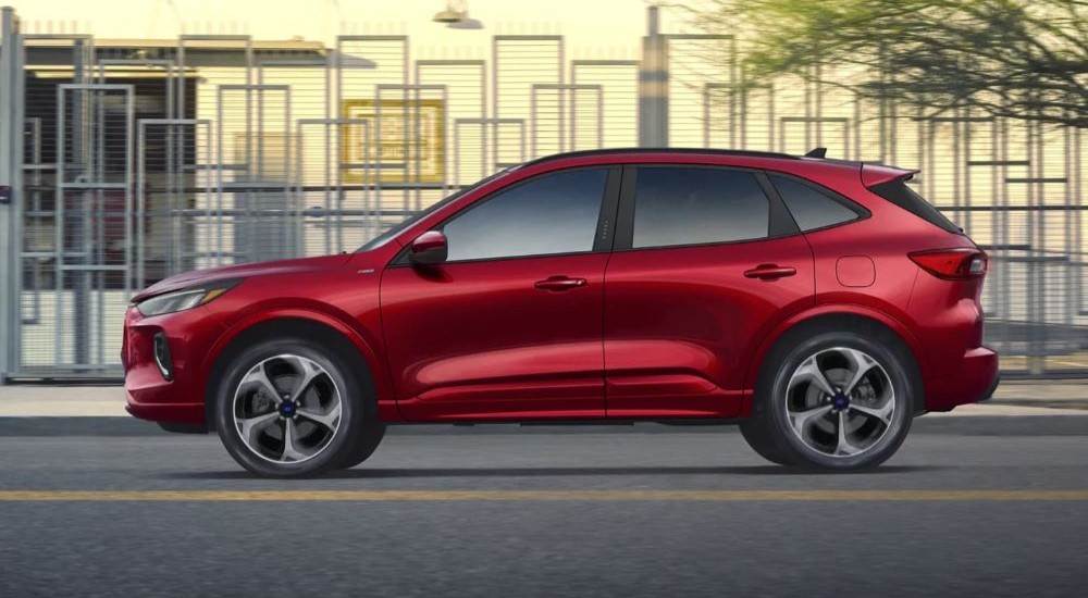 Red 2023 Ford Escape ST-Line driving on a city street