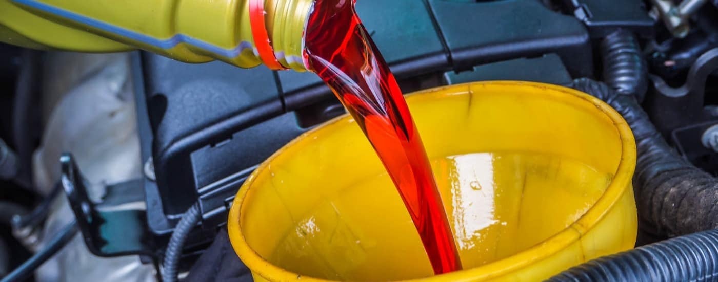 Transmission fluid is shown being poured into a funnel.