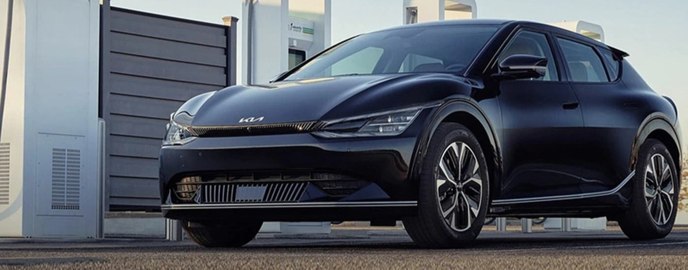 Black 023 Kia EV6 parked near charging stations