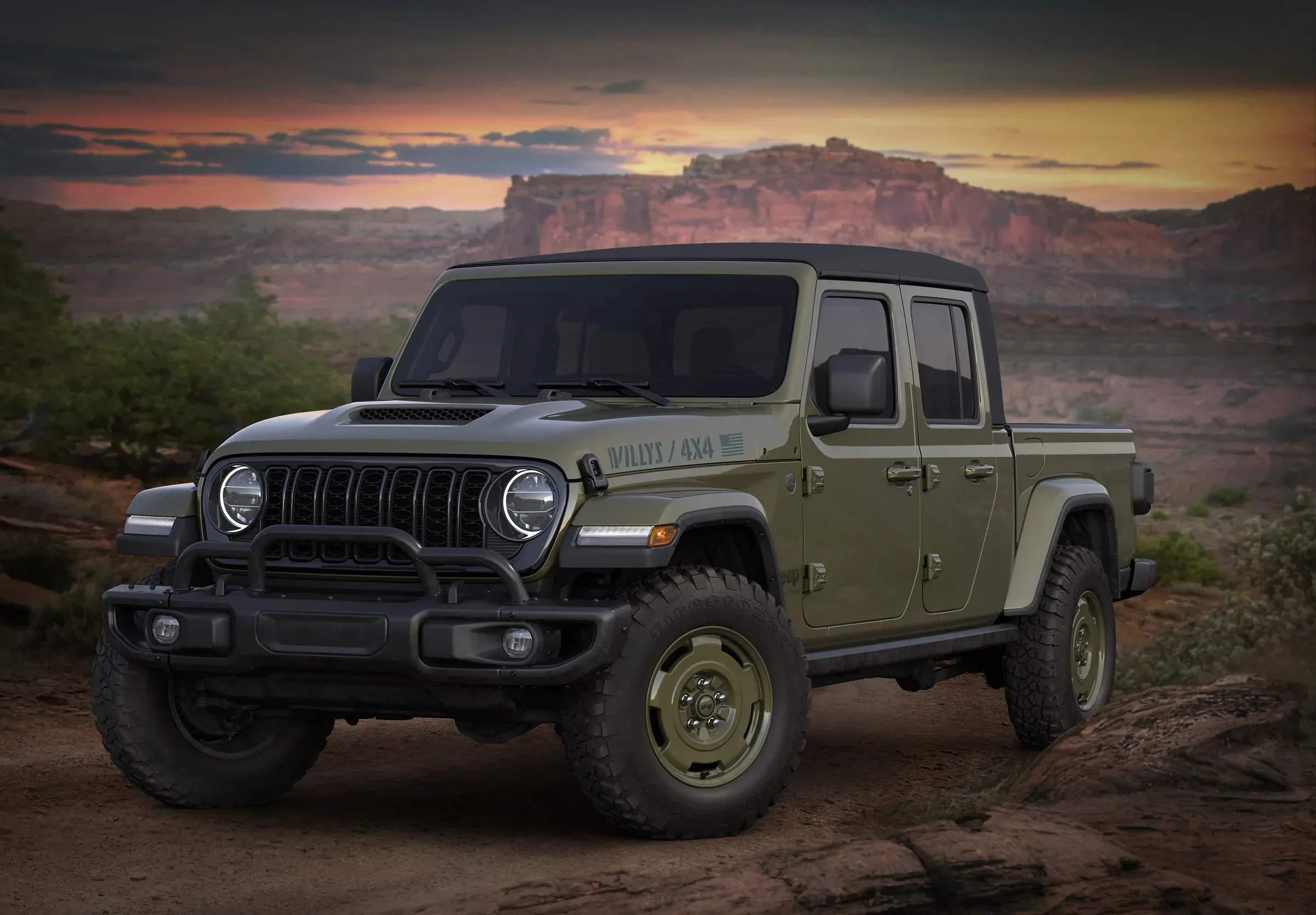 2026 Olive green Jeep Gladiator pickup truck with Willys 4x4 hood graphics parked in a desert canyon at dusk
