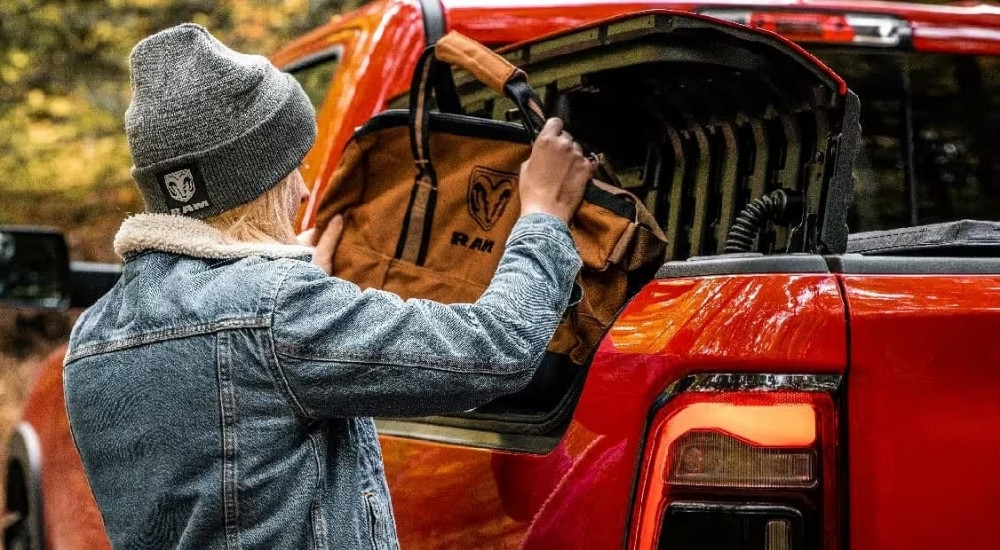 Woman using the Ram Box on a red 2023 Ram 1500