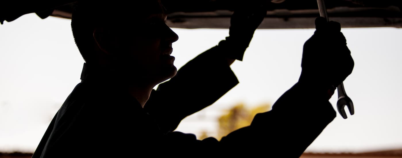 A mechanic changing an oil filter while performing an oil change near Greece.
