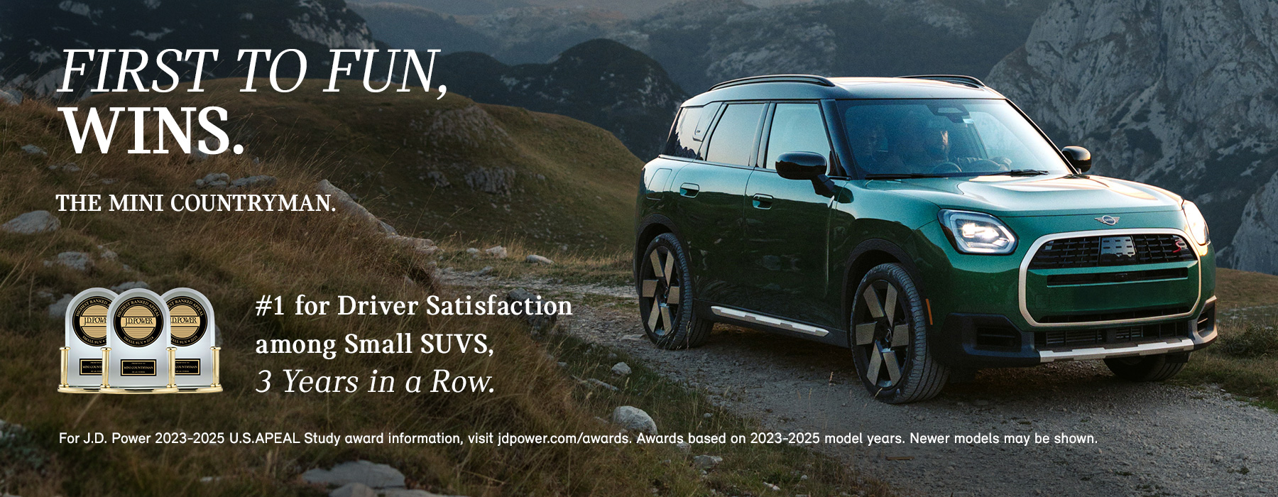 Front passenger side view of a green MINI Countryman  driving on a mountainous road.