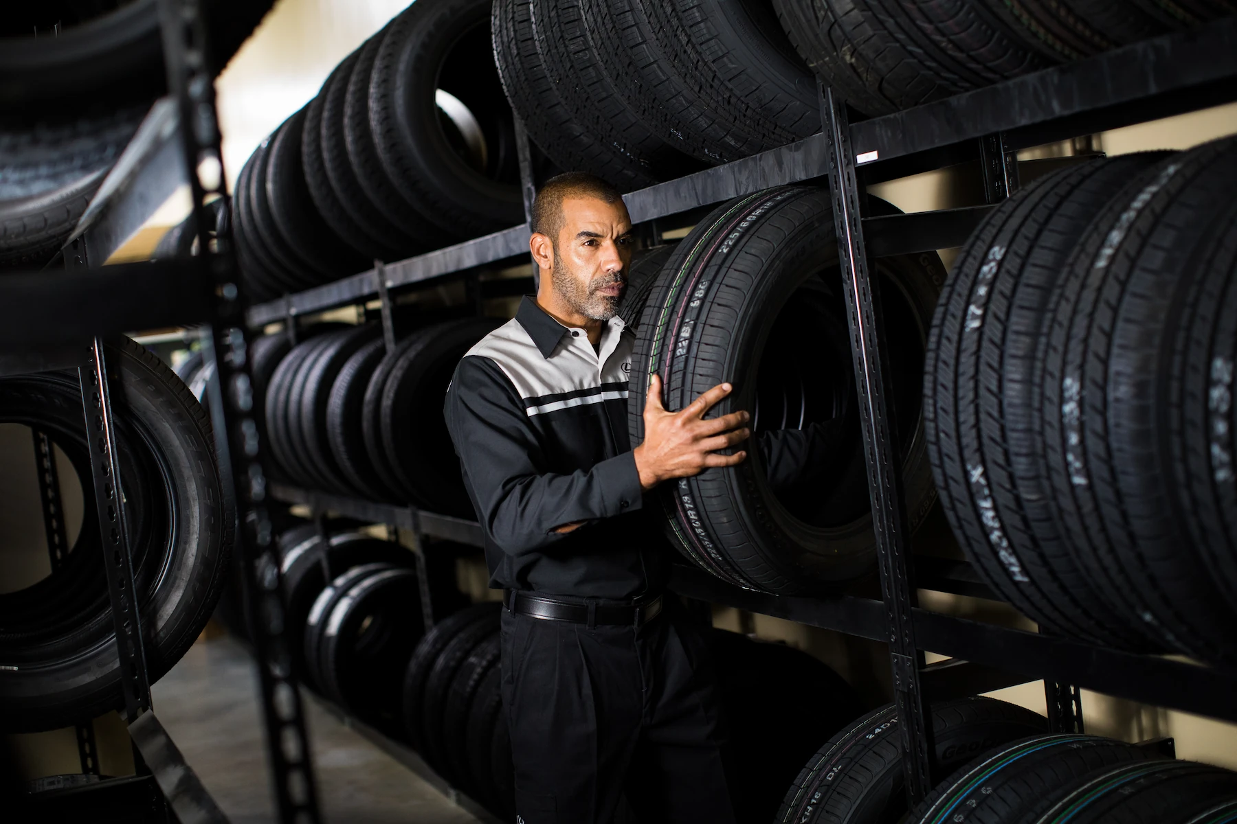 Lexus service technician selecting a tire from a stocked tire storage rack