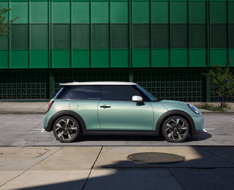 Side profile shot of metallic green MINI Cooper 2 door. 