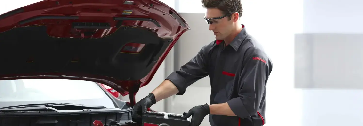 A Nissan technician providing battery care service at Kraft Nissan, ensuring your vehicle's battery is in optimal condition for reliable performance.