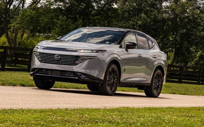 2027 Nissan Murano in red driving on a highway, high-angle rear view