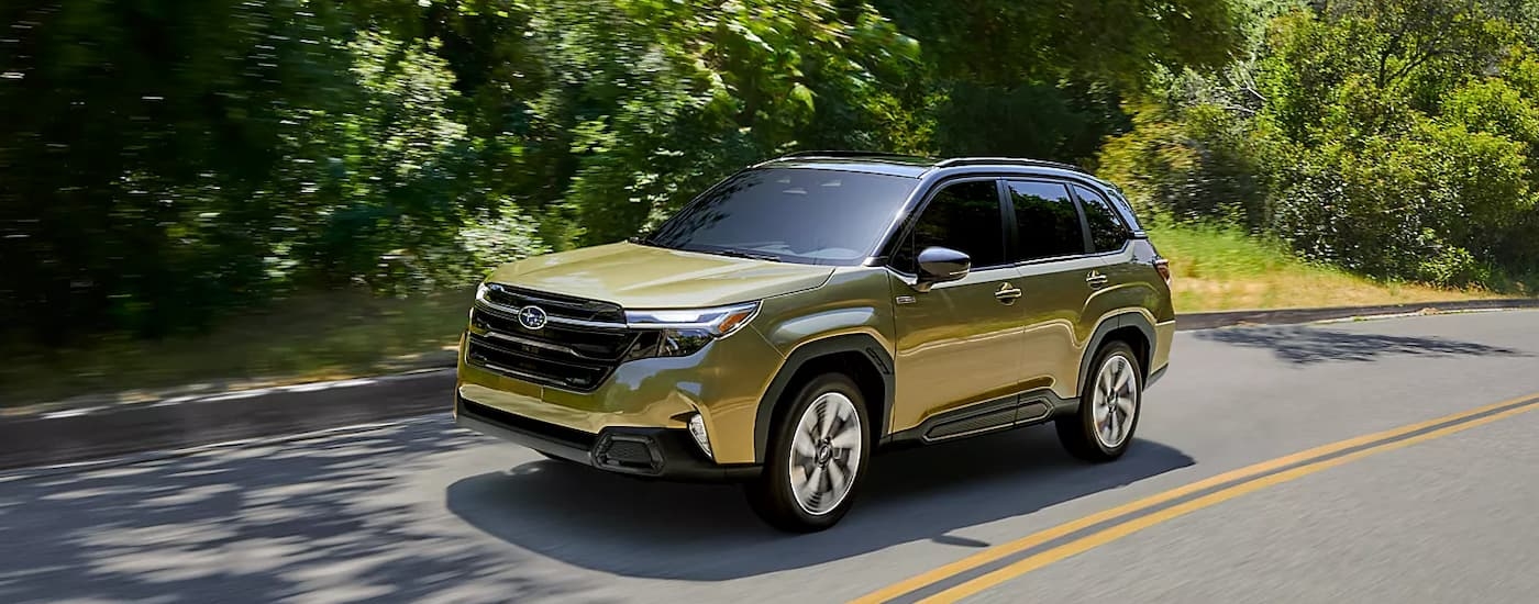 Yellow 2025 Subaru Forester driving down a road