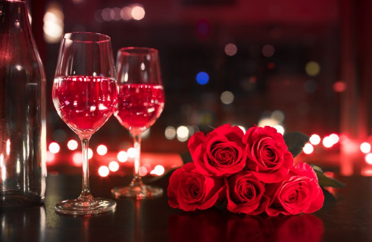 Glasses of Red Wine and Roses on a Table for Valentine's Day