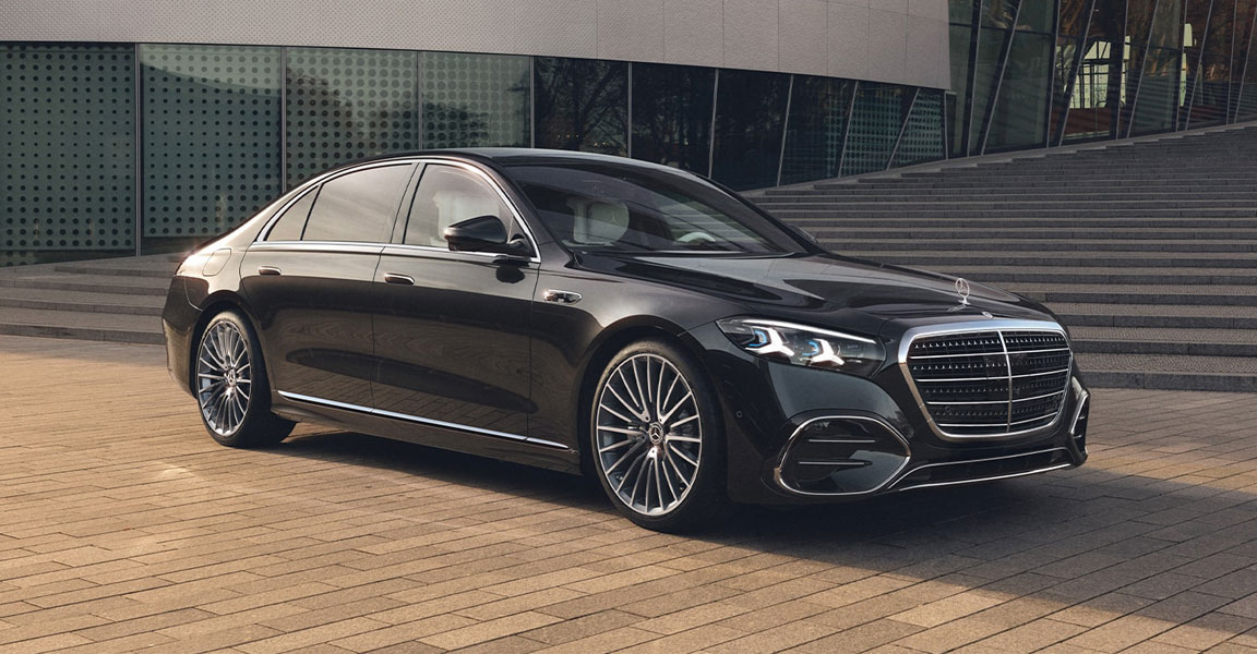 2027 Mercedes-Benz S-Class sedan in black parked outside a modern glass building