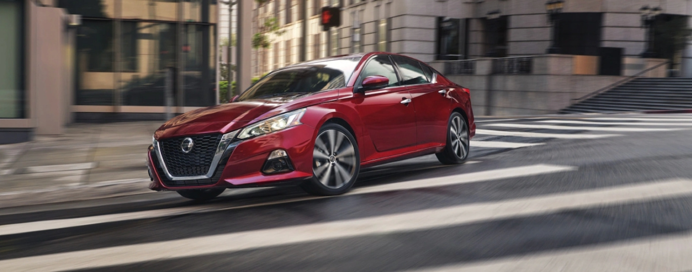 Red 2021 Nissan Altima driving to Nissan dealer near Shakopee