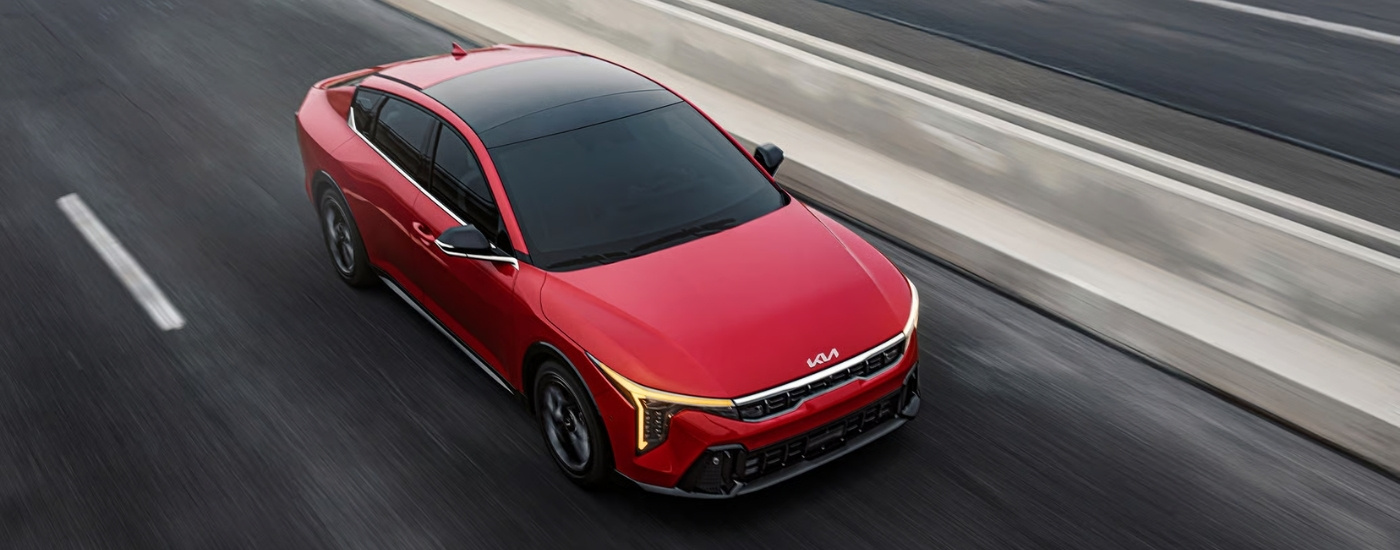 Red 2025 Kia K4 EX driving to a Kia dealer near Cudahy