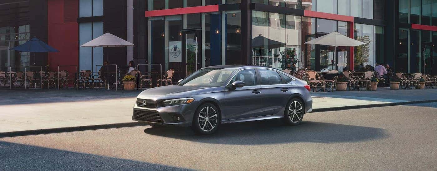 A grey 2022 Honda Civic Touring is shown parked near a coffee shop.