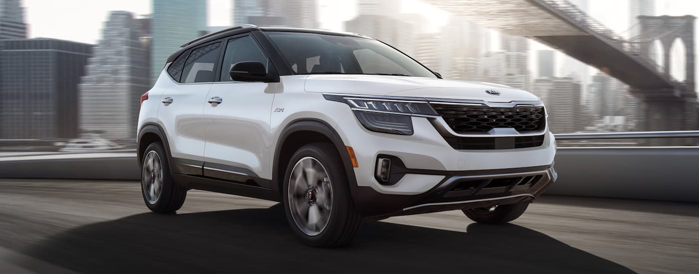 White 2021 Kia Seltos driving on a highway