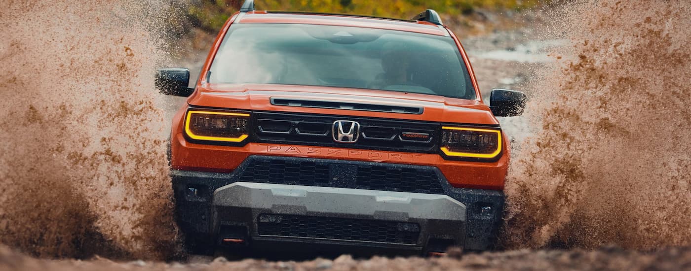 Orange 2026 Honda Passport Trailsport off-roading