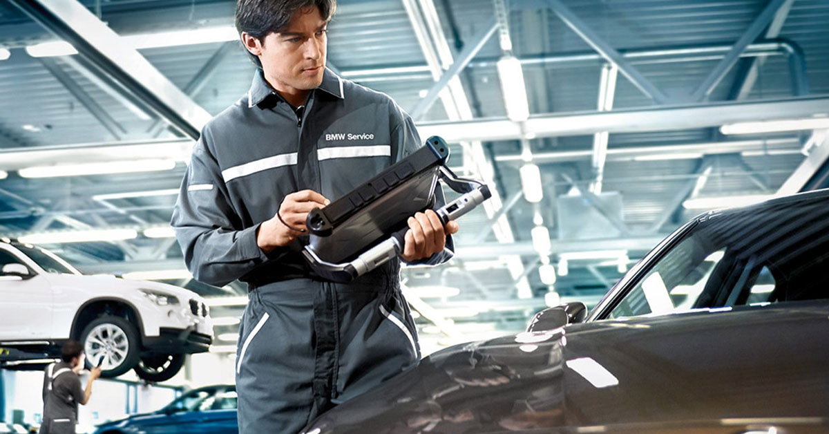 BMW service tech looking at car