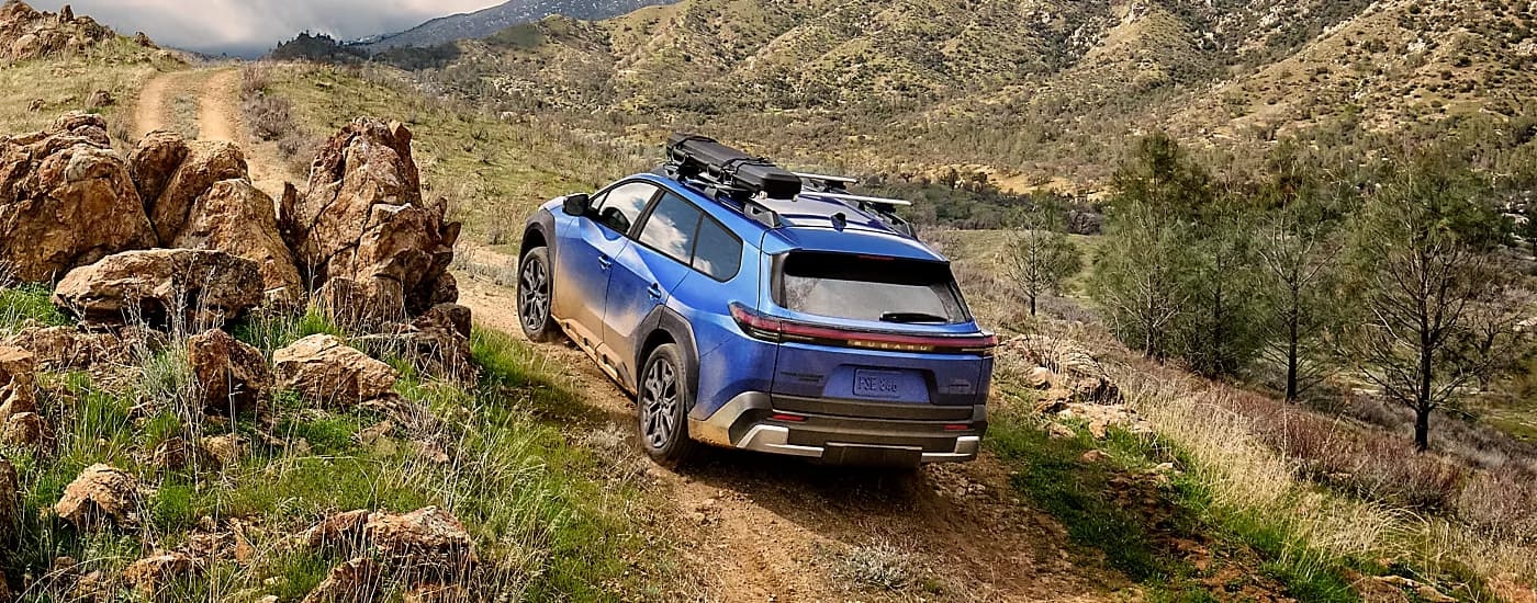 Blue 2026 Subaru Trailseeker off-roading on a mountain trail.