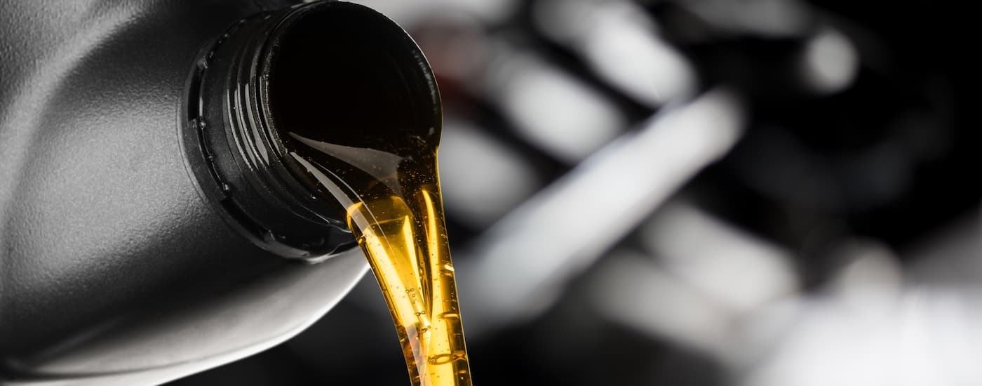 A close up of engine oil pouring out of a bottle is shown