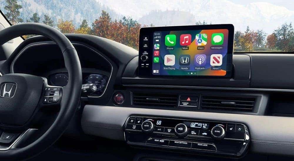 The black and gray interior and dash of a 2023 Honda Pilot is shown.