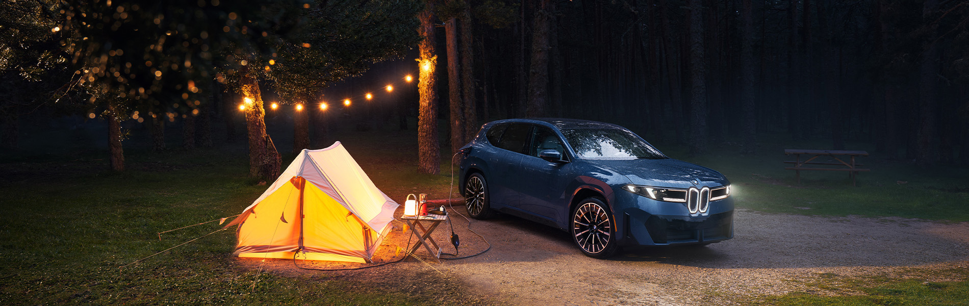 Parked BMW iX3 powering campsite.
