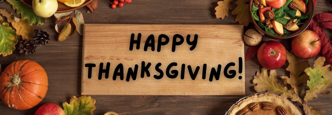 Table with Fall Decorations and Food and Happy Thanksgiving Sign