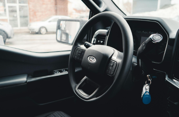 A photo of a car’s dashboard focusing on the steering wheel and power windows