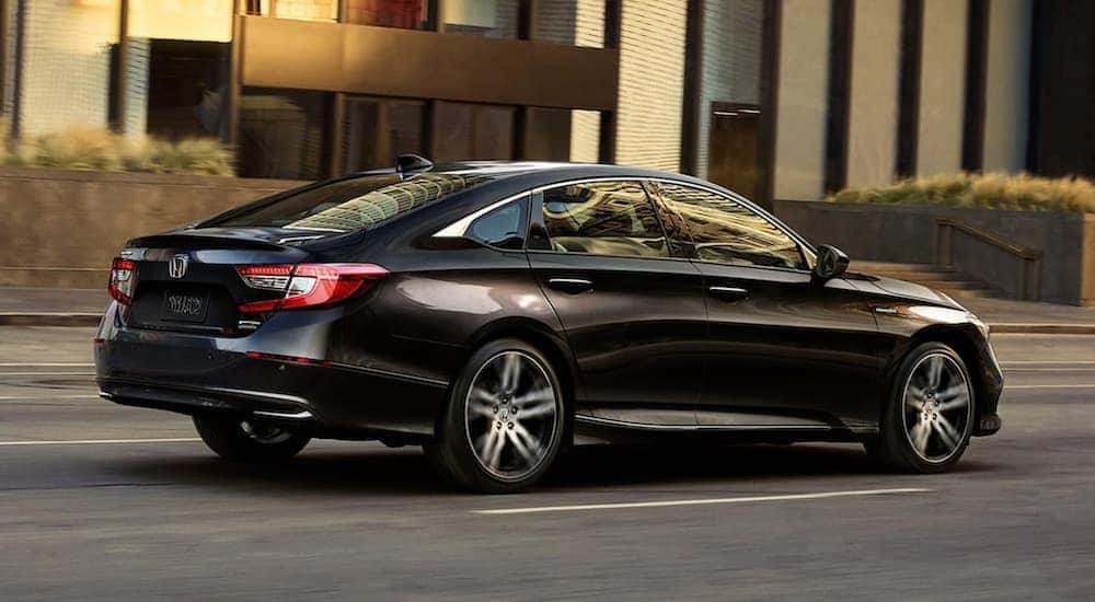 A black 2021 Honda Accord Hybrid is on a city street after leaving a Rochester Honda Accord dealer.