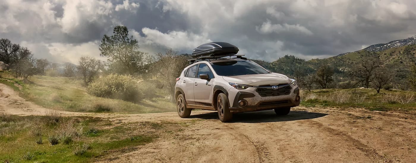 Silver 2026 Subaru Crosstrek Hybrid driving off-road down a dirt road
