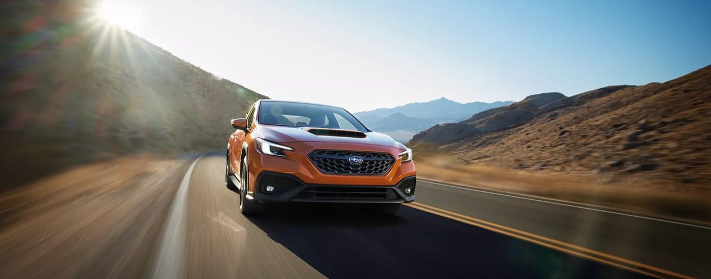 An orange 2023 Subaru WRX Limited driving.